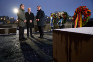 Bundesinnenminister Dobrindt, der Vorsitzende des Zentralrats der Juden Schuster und EU-Kommissar Brunner nach der Kranzniederlegung am Stelenfeld in Berlin im Gespräch © BMI, Foto: Henning Schacht