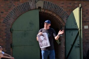 Robert Parzer mit einem Porträt von Herbert Lange vor der Gaskammer in Fort VII, Poznań